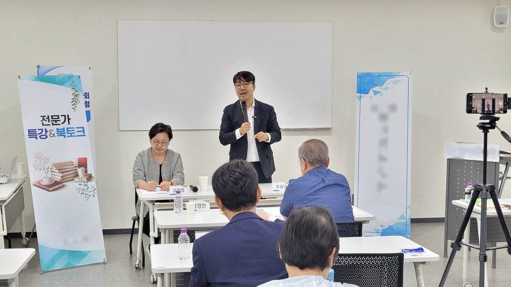 토크콘서트에서 진행자가 말하고 강연자가 앉아 있는 모습