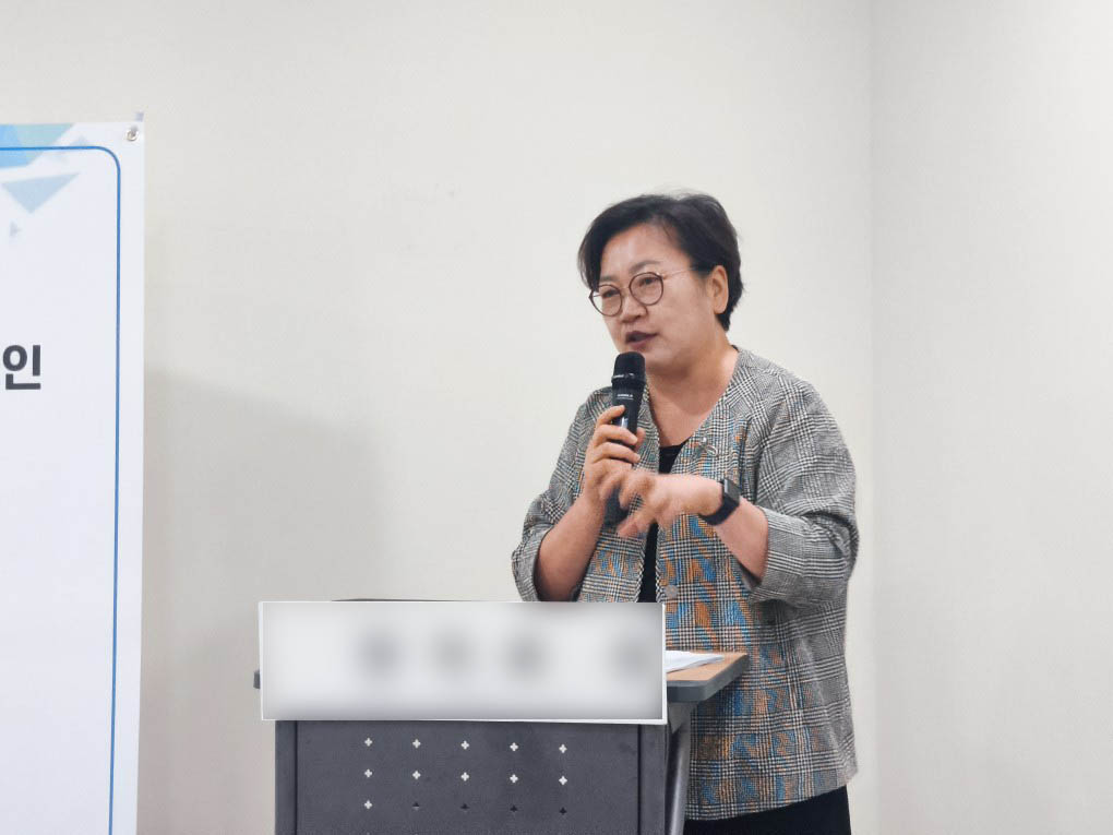 연단에서 마이크를 들고 강연하는 모습