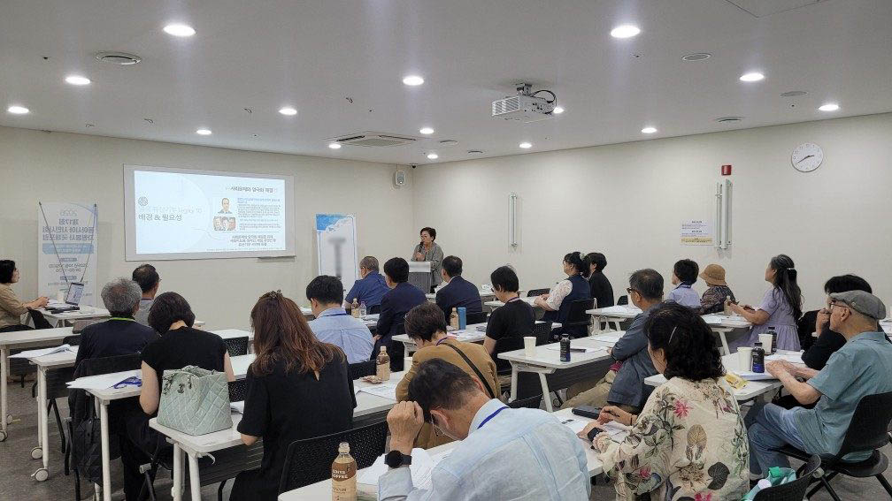 발표 화면 앞에서 강연이 진행되는 교육장 전경. 참가자들이 자리를 채우고 있다