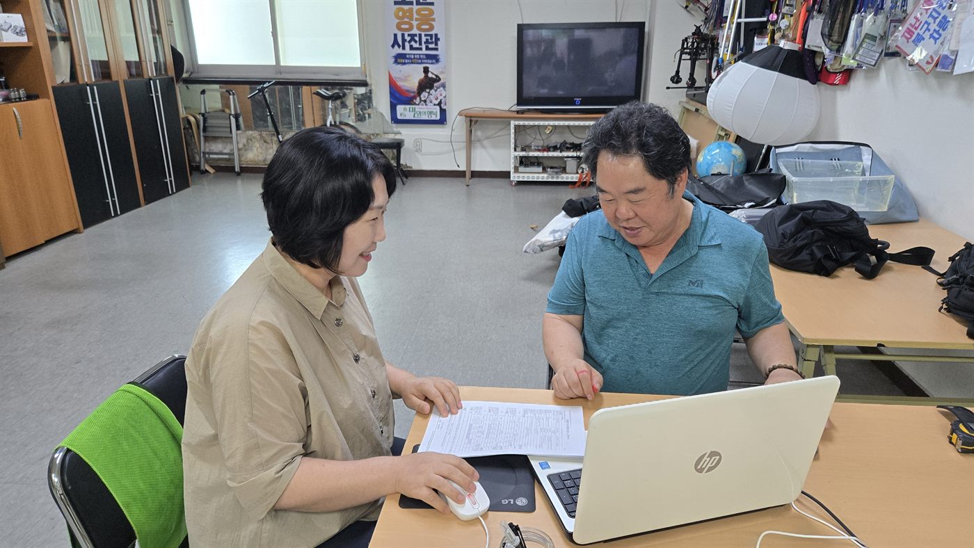 전문가와 단체 담당자가 노트북과 서류를 함께 보며 상담하고 있다