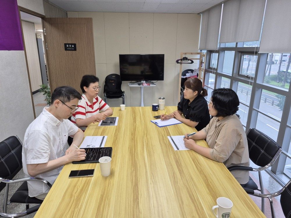 회의실 긴 탁자에 마주 앉아 자료를 보며 코칭을 진행하는 네 사람